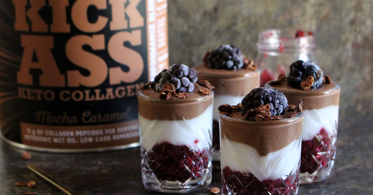 Layered black forest trifle in small glasses with decorative berries.